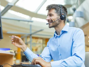 Professional customer support representative assisting users by phone and computer