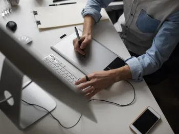 Professional working with digital content and business assets at a computer workstation