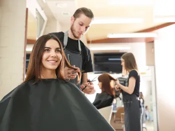 Professional hairstylist providing hair services to a client in a local salon