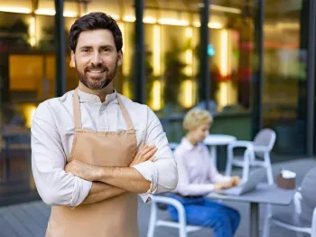 Local restaurant owner standing confidently outside a professional food business