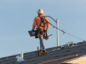 Professional roofer installing materials on a residential roof